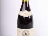 une vieille bouteille de vin posée sur une table blanche