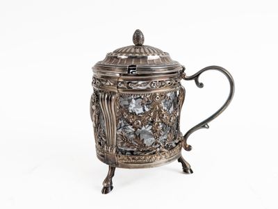 an antique silver teapot with a glass lid on a stand