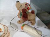 un ours en peluche posé sur une table, à côté d'une assiette