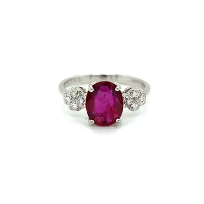 an oval ruby and diamond ring on a white background