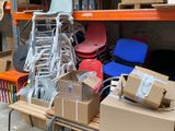Des cartons et des chaises sont empilés sur une table dans un entrepôt