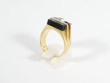a close up of a gold ring with a black stone on it