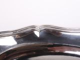 a silver plate with a curved edge on a table