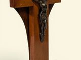 une croix en bois surmontée d'un crucifix, sur fond blanc