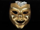 un gros plan d'un masque en or orné d'un diamant sur le dessus