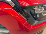 a close up of a car ' s headlight with a ruler attached to it