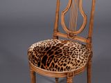 an image of a leopard print chair with a wooden frame and wooden legs