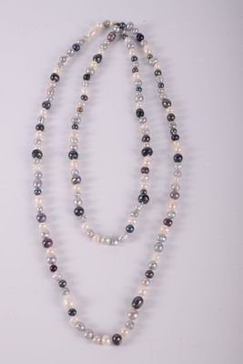 two strands of multicolored glass beads with silver clasps on a white surface