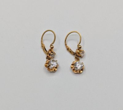 une paire de boucles d'oreilles en or et diamants sur fond blanc