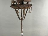 a sculpture of a man sitting on top of a tree