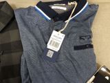 a polo shirt and a cell phone sitting on a couch