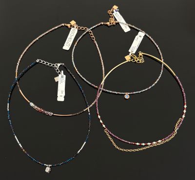 trois bracelets différents, munis d'étiquettes, sur fond noir