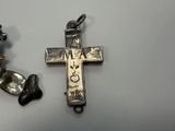 two pieces of silver and a silver cross on a table