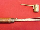 an old metal tool with a wooden handle sitting on a red surface