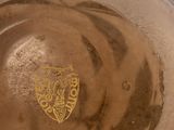 a close up of a brown hat with a crest on it