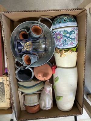 a cardboard box filled with vases and other items