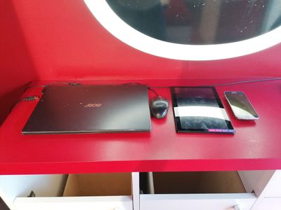 un bureau rouge sur lequel se trouvent un ordinateur portable et une souris