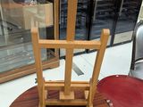 a wooden chair that is on a table in a store