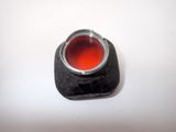 a ring with a red substance in it on a white surface