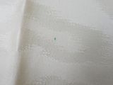 a small green dot in the middle of the white fabric