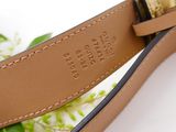 a close up of a belt with a flower in the background