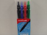 quatre stylos dans un emballage posé sur une surface blanche