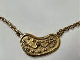 a gold plated necklace with a fish on it