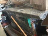 une pile de cartons posée sur un bureau dans une pièce encombrée