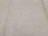 un gros plan sur une nappe blanche ornée d'un monogramme