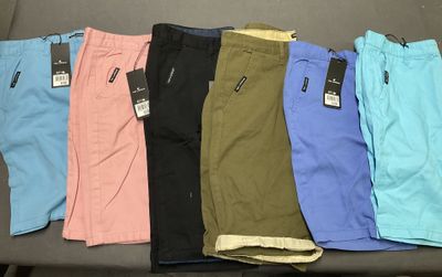 Plusieurs paires de pantalons pour hommes sont alignées sur une table