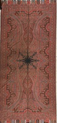 an old red and black rug with a spider on it