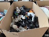 many pairs of shoes in a cardboard box on the floor