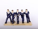 three figurines of men dressed in navy uniforms stand on a wooden base
