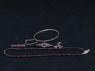 an image of a necklace and a bracelet on a black surface
