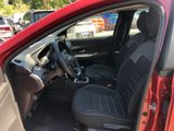 the interior of a red car with black seats and a steering wheel