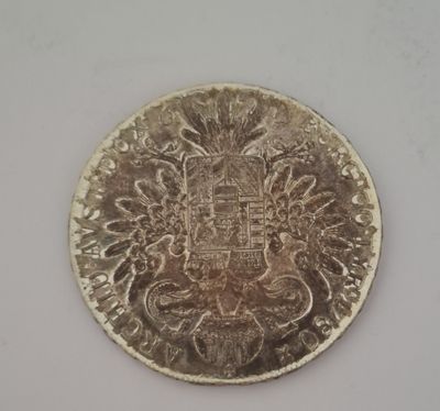 un gros plan d'une pièce d'argent sur laquelle figure un blason