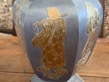a blue vase with gold designs on it on a wooden table