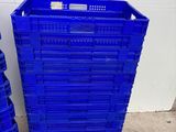 two blue plastic crates stacked on top of each other in a warehouse