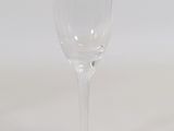 a clear wine glass sitting on a white surface