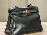 an old black leather purse sitting on top of a wooden table