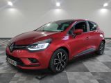 une voiture rouge est garée dans une pièce au sol en damier