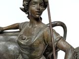 a bronze statue of a woman with a horse and a cow
