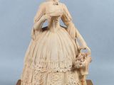 statue of a lady with a basket of flowers on a wooden base