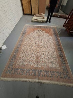 a man standing in a room with a rug on the floor