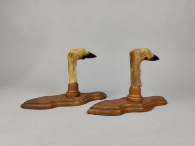 une paire de canards en bois au bec noir, posés sur une surface blanche