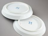 two white plates with blue flowers on them on a gray surface