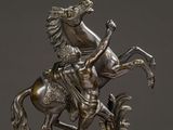 a bronze statue of a man on a horse on a marble base
