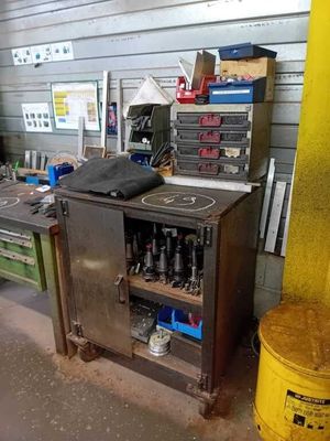 une armoire métallique dans un garage, sur laquelle sont posés des outils