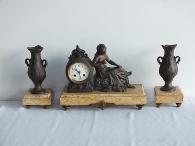 trois vases et une horloge posés sur une table