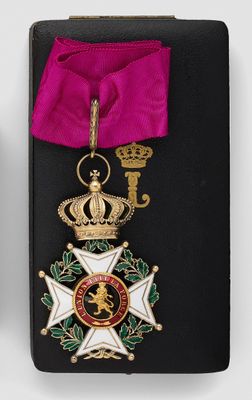 two medals and a pink ribbon are on a black case